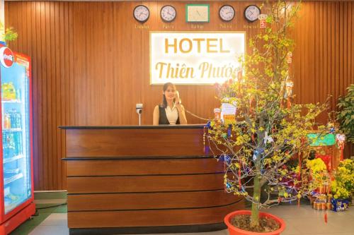 a woman standing behind a counter in a hotel titan purse at Thiên Phước Hotel in Ho Chi Minh City