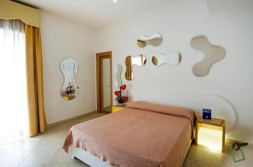 a bedroom with a bed and some art on the wall at Hotiday Gallipoli Centro in Gallipoli