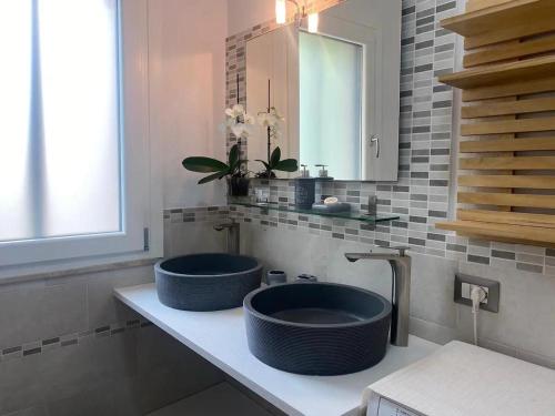 a bathroom with two blue sinks on a counter at Villa Terrazza sul Mare in Budoni
