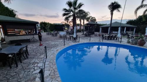 una gran piscina azul junto a un restaurante en Vacanze in Villa, en Nardò