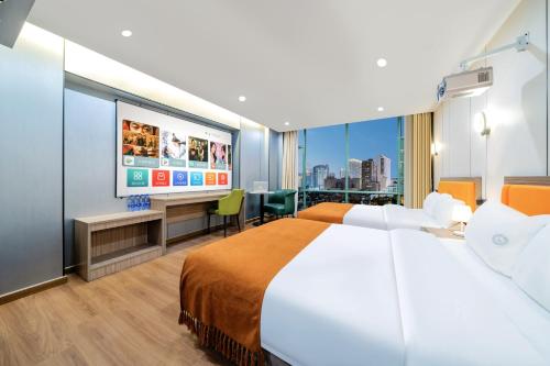 ein Hotelzimmer mit einem Bett und einem Flachbildfernseher in der Unterkunft Anman Four Seasons Apartment (Beijing Road Pedestrian Street Branch) in Guangzhou