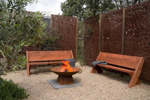 two benches and a fire pit in a garden at The Old Library in Balnarring Beach
