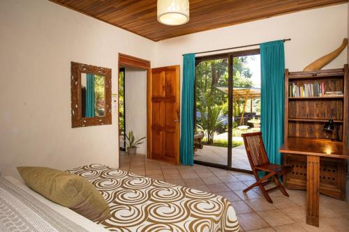 a bedroom with a bed and a desk and a piano at Toucan Villa Family home w Private Pool Garden AC in Quepos