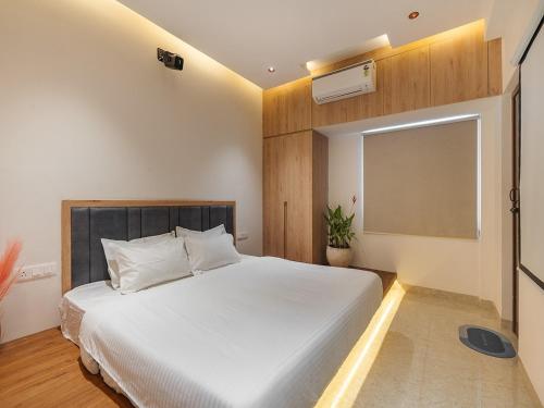 une chambre avec un lit blanc et une fenêtre dans l'établissement Serenity by Palette Homes, à Pīlamedu