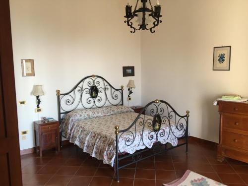 a bedroom with a bed and a chandelier at La Casa Del Nonno Raffaele- Country house in Ravello