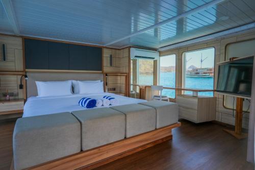 a bedroom with a bed and a tv on a boat at Komodo Top Sailing in Labuan Bajo