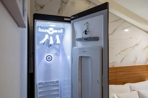 einen kleinen Kühlschrank in einem Zimmer neben einem Bett in der Unterkunft Suwon Dono1796 Hotel in Suwon