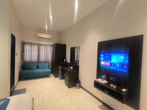 a living room with a blue couch and a flat screen tv at Shubham Residency Thane in Kālva