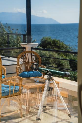 a camera on a tripod next to a table and chairs at Villa Spawn - Almost Sea in Mytikas