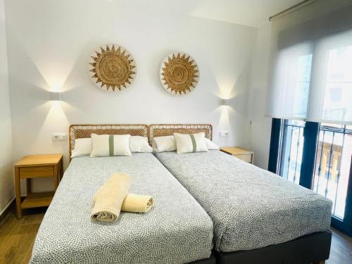 a bed in a bedroom with two mirrors on the wall at Apartamentos San Nicolas Jaca in Jaca