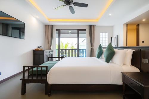 une chambre avec un grand lit avec un ventilateur de plafond dans l'établissement Manyo Hotel and Resort, à Luang Prabang