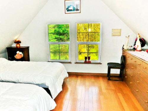 Postel nebo postele na pokoji v ubytování Guest House Ito3F 屋根裏部屋丘の上白亜の洋館風別荘静かな小さなお宿1名から3名