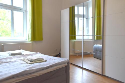 a bedroom with a bed and a mirror at GUWO Gästewohnung Straupitzstraße 12 in Guben