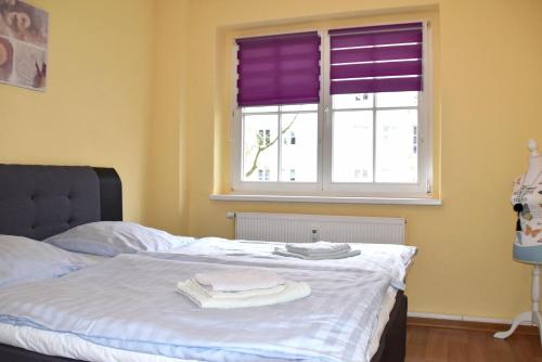 a bedroom with a bed and a window with purple blinds at GUWO Gästewohnung Friedrich-Engels-Str 5 in Sprucke