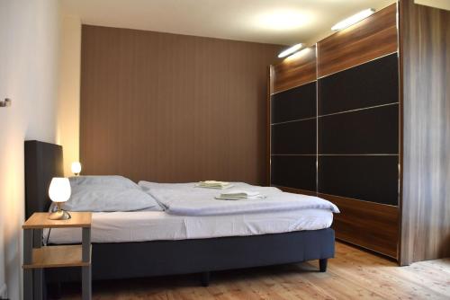 Un dormitorio con una cama y una mesita de noche junto a un armario. en GUWO Gästewohnung Friedrich-Schiller-Str 27, en Guben