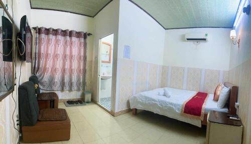 a small bedroom with a bed and a mirror at Tân Tuấn Tuấn Hotel in Ho Chi Minh City