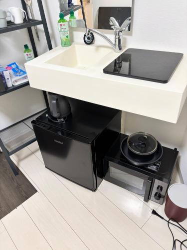 a sink under a kitchen counter with a pot holder under it at #45#46 2-factor authentication Shinjuku in Tokyo