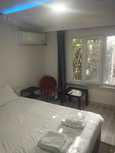 een slaapkamer met een bed, een stoel en een raam bij Şişli Suites - Room 14 in Istanbul