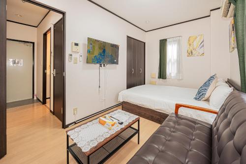 a hotel room with a bed and a couch at Japan House Oshiage in Tokyo