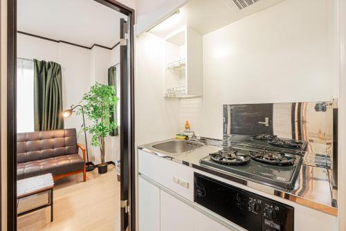 a kitchen with a stove top oven next to a sink at Japan House Oshiage in Tokyo
