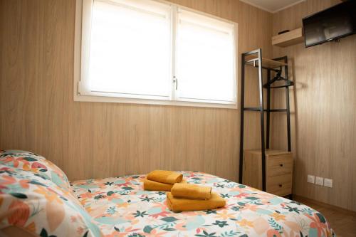 a bedroom with a bed with yellow towels on it at La Cabane de Camille in Pithon