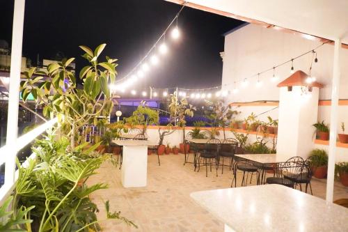 Un restaurante con mesas, sillas y luces. en Khangsar Home, en Katmandú