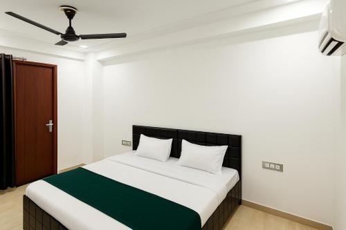 1 dormitorio con 1 cama con sábanas blancas y verdes en Ditvi residency, en Gurgaon