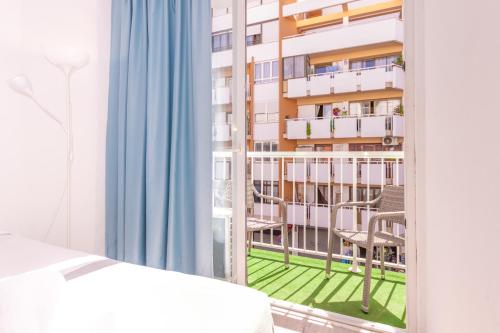 a bedroom with a window with a view of a balcony at Hotel Boogaloo - Adults Only in El Arenal