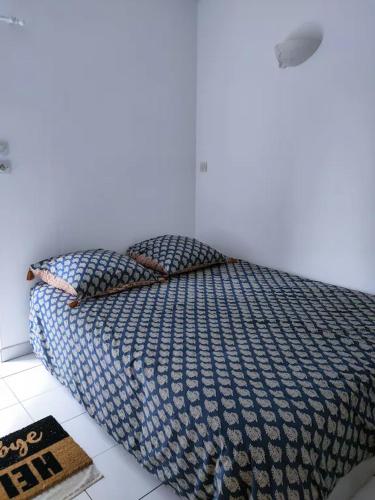 a bedroom with a bed with a blue comforter at Studio "Rêves de gamins" proche du pôle Européen et circuit des 24h, Champagné in Champagné