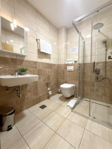 a bathroom with a shower and a toilet and a sink at Hotel "Izvor Bosne" in Sarajevo