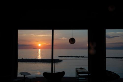 a view of a sunset from a room with a window at TORIKKA Stay -ビーチに建つ貸別荘- in Sumoto