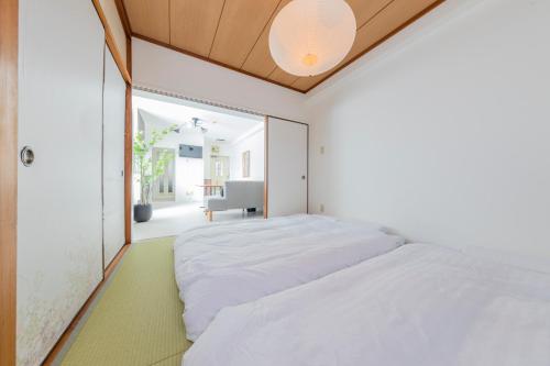 a bedroom with a large white bed with a ceiling at エドモダンステイ Edo Modern Stay 01 in Tokyo