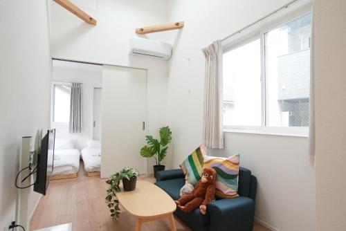 a teddy bear sitting on a blue chair in a living room at Green Palace Tennoji in Osaka