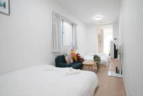 a bedroom with two beds and a couch and a table at Green Palace Tennoji in Osaka