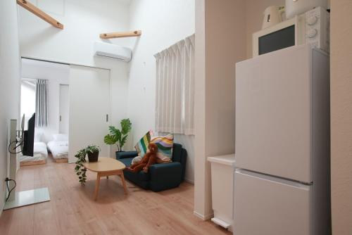 a living room with a refrigerator and a chair at Green Palace Tennoji in Osaka