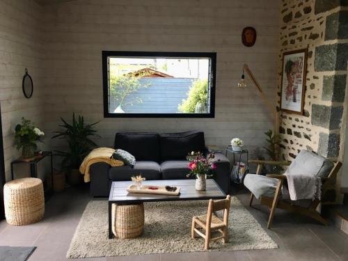 een woonkamer met een bank en een tafel bij Spacieuse maison avec piscine in Plédran