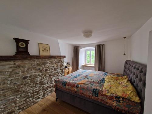 Un dormitorio con una cama y una pared de piedra. en Ferienhaus Das Gloria, en Blankenheim
