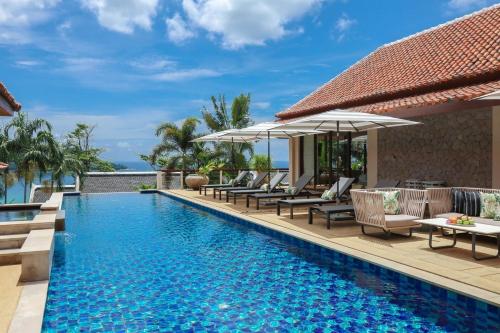 a pool at a resort with chairs and umbrellas at Katamanda Villa Allegra 5 bedroom Seaview villa in Ka Rorn