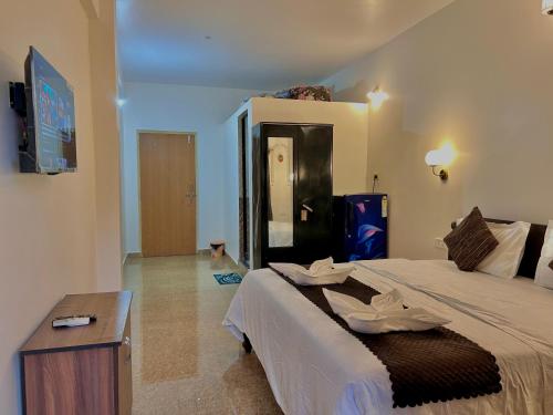 a bedroom with a large bed and a tv at Alex beach inn in Calangute