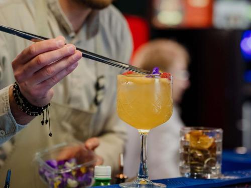 a person is stirring a drink with a chopstick at Mercure Timisoara in Timişoara