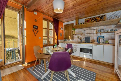 a kitchen with a glass table and purple chairs at À Deux Pas ... in Briançon