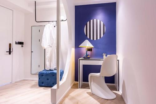 a living room with a chair and a desk at Chongqing Nanqing·World Time Hotel in Nan'an