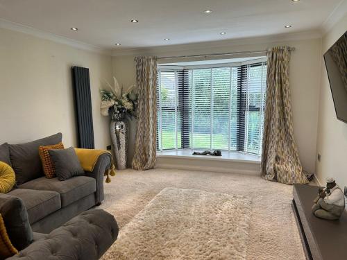 a living room with a couch and a large window at Lanrest in Talacre