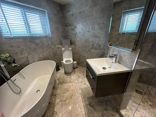 a bathroom with a tub and a toilet and a sink at Lanrest in Talacre