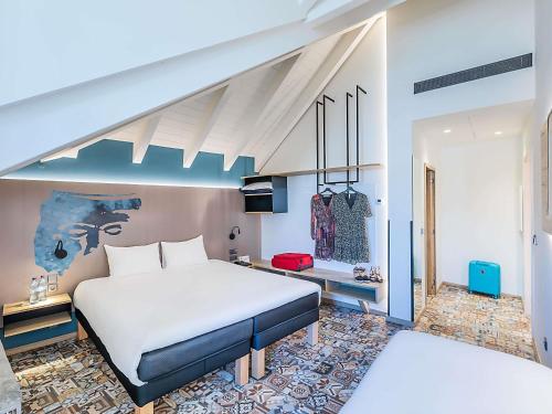 a bedroom with a large white bed and a desk at ibis Styles Chaves in Chaves