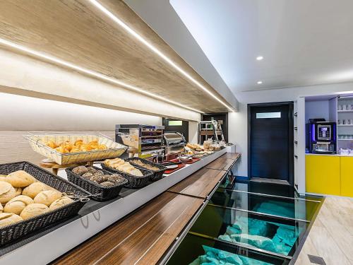 una panadería con pan y bollería en una barra en ibis Styles Chaves, en Chaves