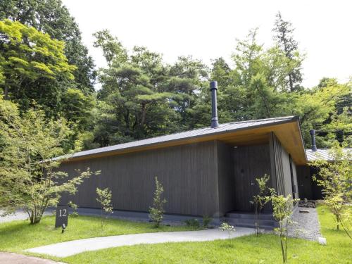 a building with a roof with trees in the background at Hakone Retreat villa 1/f in Hakone