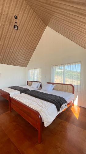 a large bed in a room with two windows at Umacabana 2 in Dieng