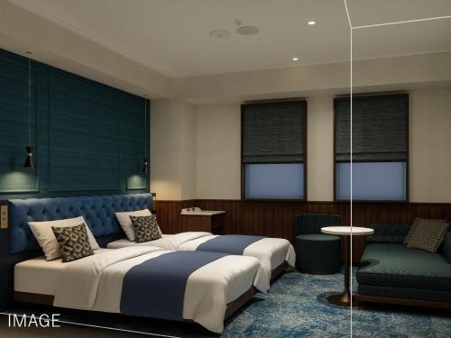 una habitación de hotel con dos camas y un sofá en Villa Fontaine Tokyo Hibiya, en Tokio