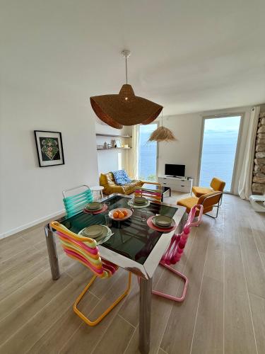 a living room with a table with colorful chairs at Casa Favelas, Vue Mer et Proche de Monaco in Cap d'Ail